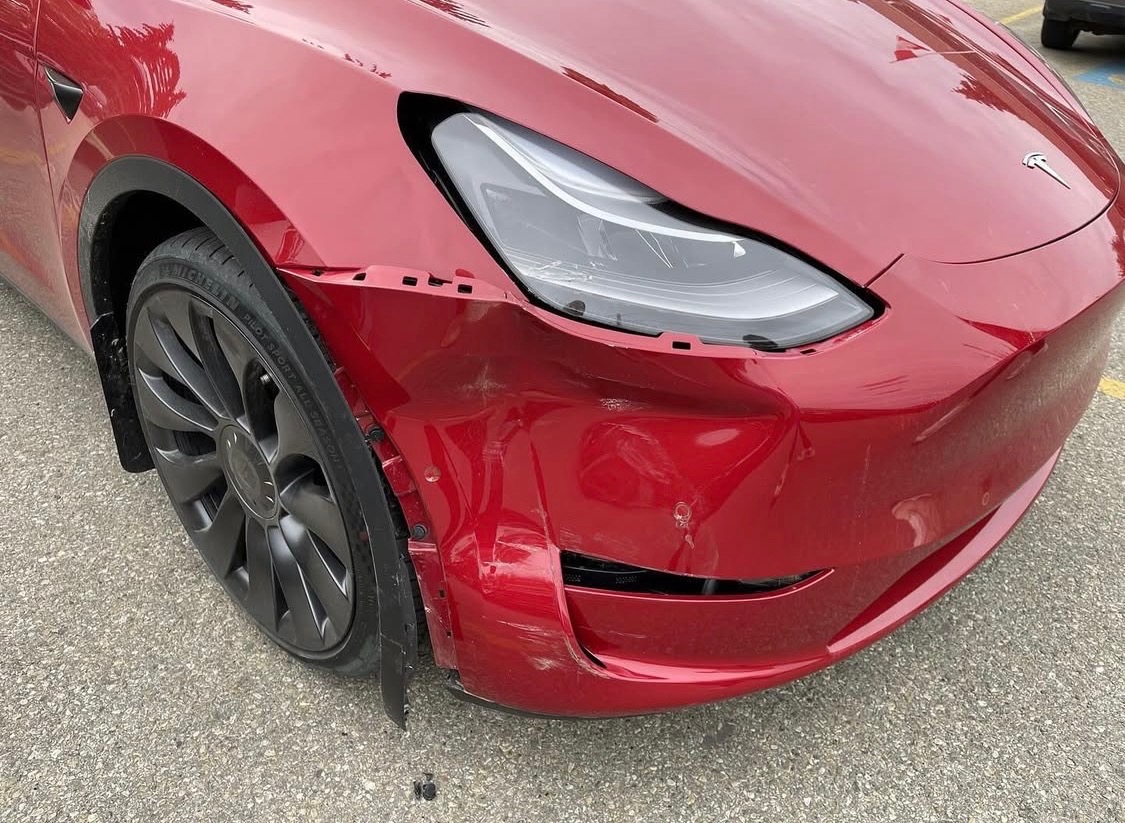 Red Tesla front bumper damage before repair