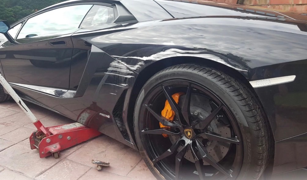 Black Lamborghini quarter panel scratch damage